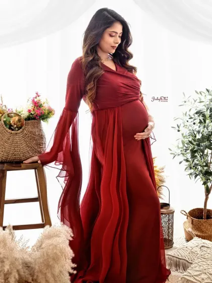 This mama-to-be looks absolutely breathtaking in a flowing red gown. The natural elements like the wicker baskets and olive plant add a touch of earthy elegance to this solo maternity portrait.
