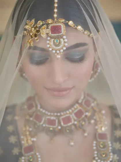 A dreamy, artistic shot of a bride with deep teal smokey eyes. The veil adds a layer of mystique to this beautiful and dramatic look.