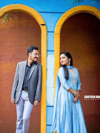 A relaxed and stylish portrait of a couple against a colorful, modern backdrop.