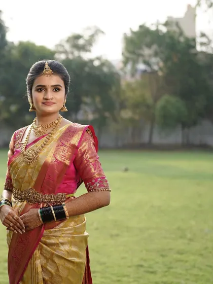 Priyanka looking serene and beautiful in an outdoor setting for her wedding photos. The makeup is soft and natural, perfect for daylight photography.