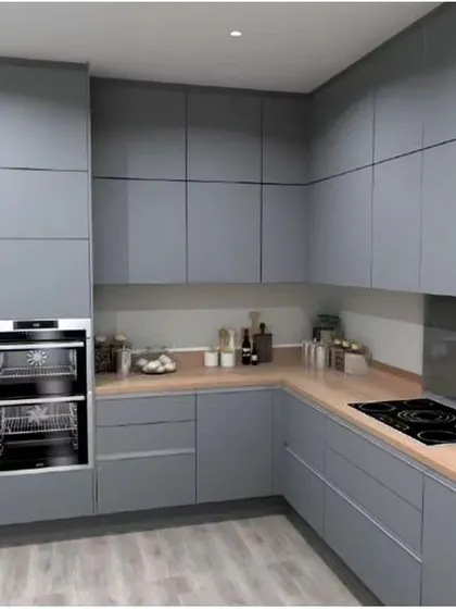 This kitchen features floor-to-ceiling matte grey cabinets for a seamless, modern look. The integrated double oven and wood-look countertop complete the sophisticated design.