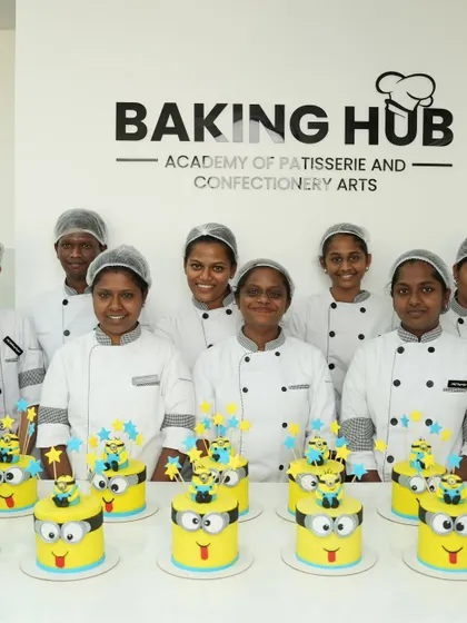 A group of happy students with their identical, perfectly crafted Minion cakes. This shows how our step-by-step instruction ensures everyone can achieve consistent, professional results.