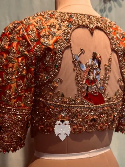 Another angle of the Radha Krishna blouse, showcasing the jeweled neckline and floral designs on the body and sleeves.