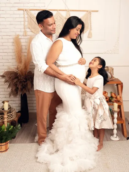 A beautiful moment of connection between all three family members. The daughter's gentle touch on her mother's baby bump is a precious memory of this special time.