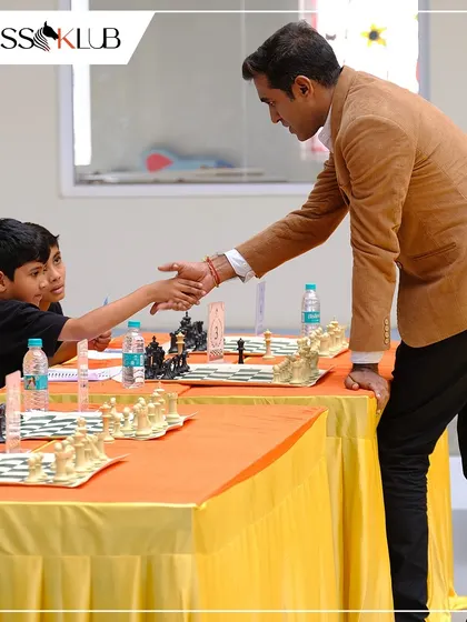 A handshake of respect between a young competitor and Grandmaster M.S. Thejkumar after a challenging simultaneous chess match. These are the moments that inspire our players.