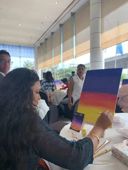 A participant at the BMW event working on her sunset painting. Art can be a peaceful escape, even in the middle of a bustling event.