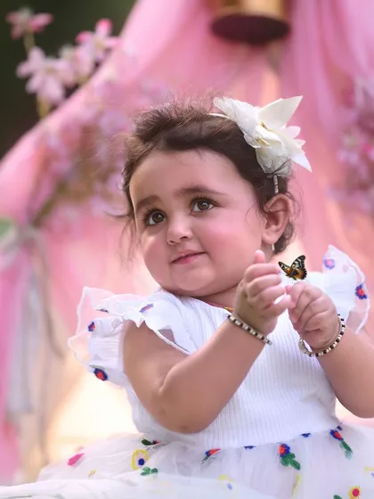 Wonder and curiosity in her eyes. I use elements like floating butterflies to add a touch of magic to first birthday photoshoots, creating an enchanting scene for your little one.