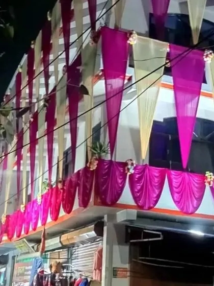 A house facade at night decorated with vertical drapes in off-white and pink, creating an elegant and festive look.