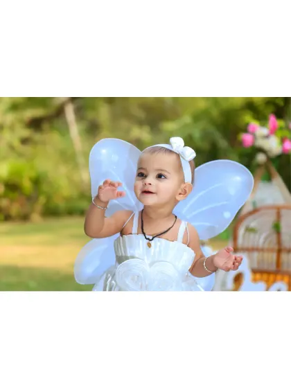 A close-up of the little birthday fairy in her white dress and wings.