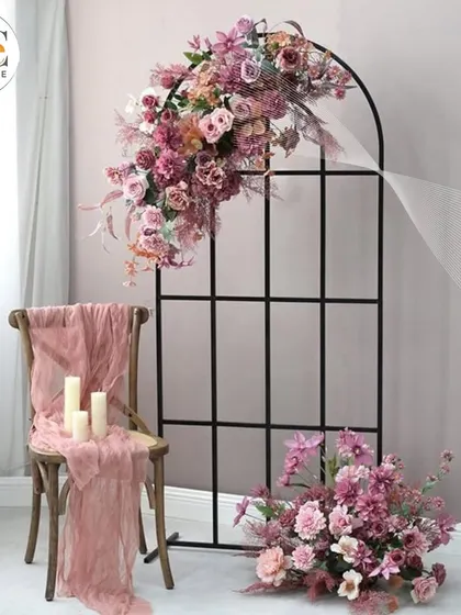 A minimalist yet elegant decor piece. The black metal arch with an asymmetrical floral arrangement is perfect for modern, understated events.