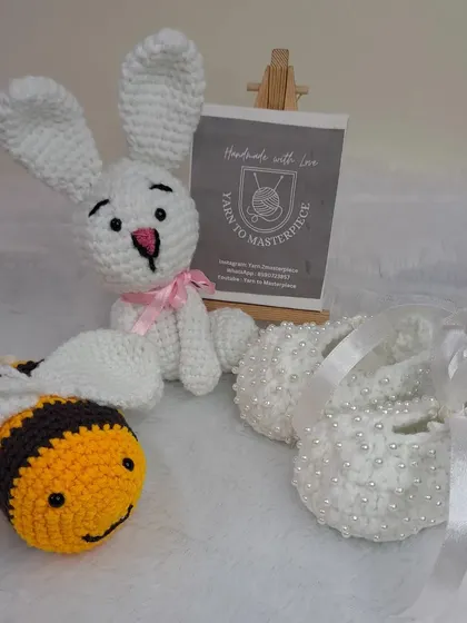 This custom gift hamper was created for a baby girl, featuring a bunny doll, a bee toy, and a pair of my classic white pearl booties.