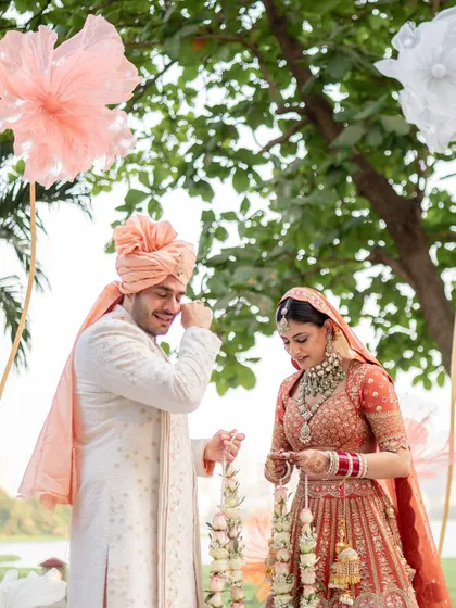 The couple sharing a lighthearted moment during their Varmala ceremony, their smiles telling a story of friendship and love.