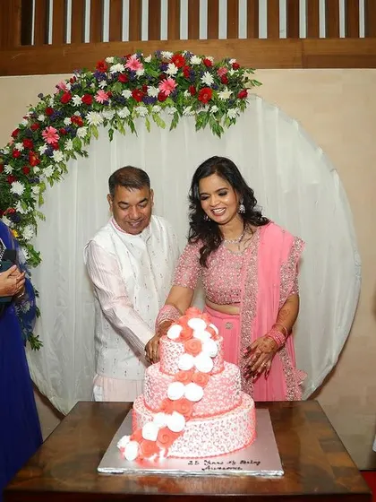 A happy family celebrating their 25th anniversary in front of the circular floral backdrop we designed.