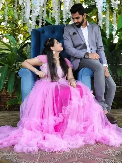 A royal themed pre-wedding shoot with the couple seated on thrones. The client wears our bright pink ruffled gown.
