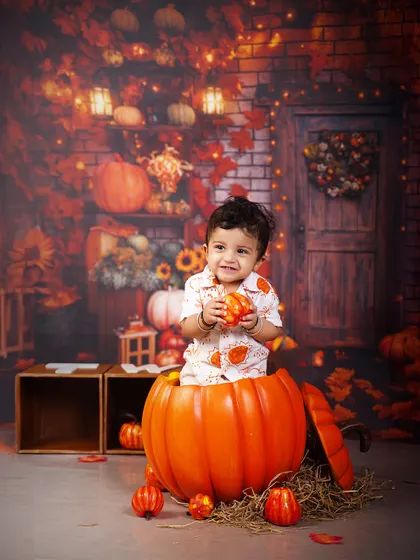 A little pumpkin full of joy. This happy baby pops out of a large pumpkin prop, creating an adorable and unforgettable photo.