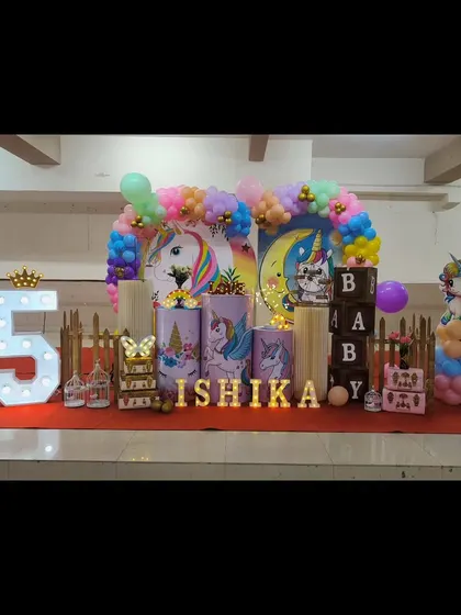 Our unicorn theme is pure magic. This setup for Ishika's birthday features pastel unicorn illustrations on pedestals, a rainbow balloon arch, and light-up letters for an enchanting party.