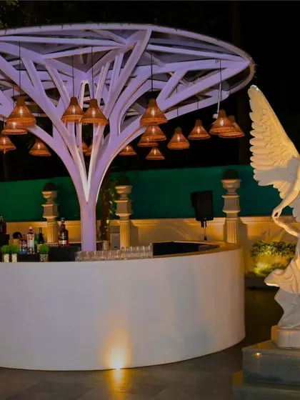A truly unique bar setup. The circular bar was built around a sculptural tree with hanging lamps, watched over by an angelic statue, creating an artistic and memorable focal point for the reception.