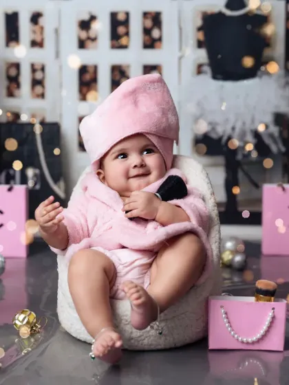 A happy smile from our little diva, holding a makeup brush in her own mini salon.