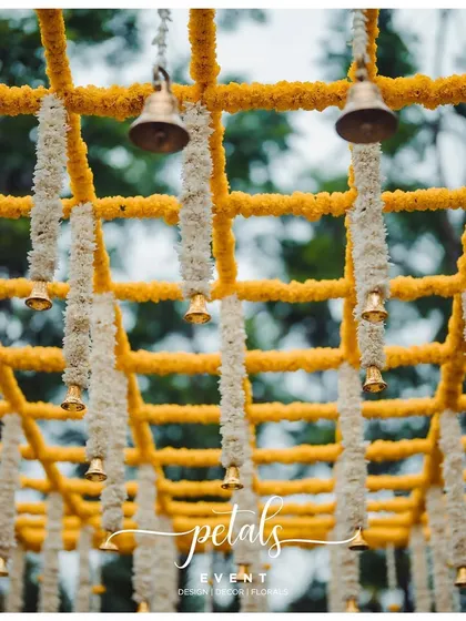 The ceiling of this mandap is a work of art, with a grid of marigolds and chrysanthemums and hanging temple bells.