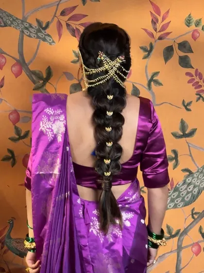 For Ganesh Chaturthi, we created this divine Gauree Devi look. The messy braid is adorned with a traditional Chandrakor, perfectly complementing the purple nauvari saree and temple jewelry.