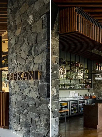 The entrance to the restaurant and the bar area at the Radisson Resort are defined by heavy stone pillars and rich wooden details, grounding the modern design in the region's material history.