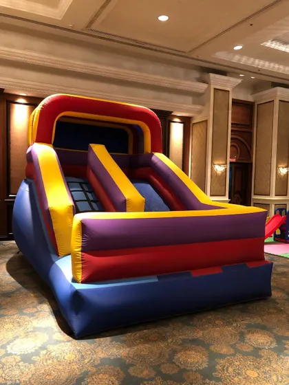 This compact inflatable slide is specifically designed for indoor use in venues like banquet halls with limited space. It provides a fun sliding experience for younger children in a safe, contained unit.