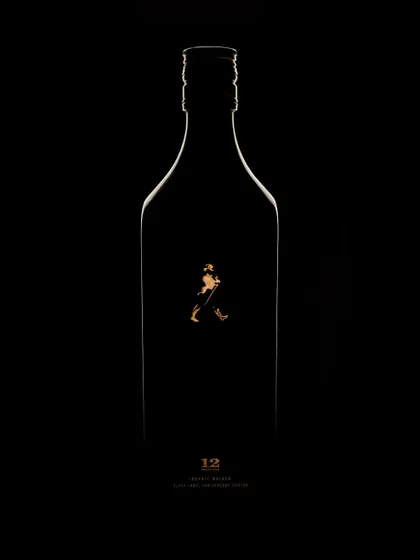 A wider view of the minimalist Johnnie Walker concept. Here, you see the full silhouette of the bottle, defined by a thin, golden line of light. It's a testament to how much can be said with very little, focusing on shape and brand identity.