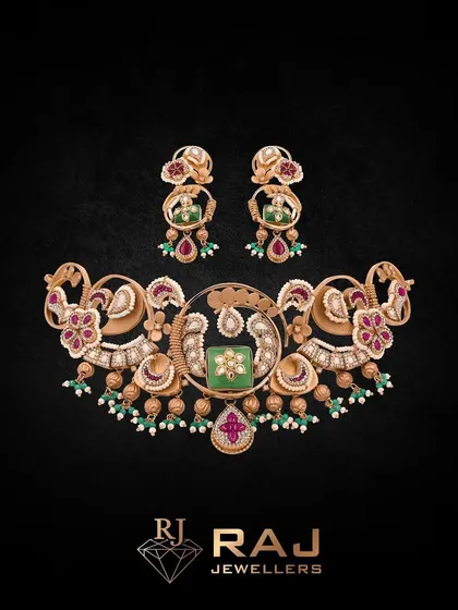 Introducing the Raanisa Collection by Revaj, this choker set is fit for royalty. The intricate design features floral and peacock motifs, with a central green stone framed by polki and pearls, embodying timeless beauty and craftsmanship.