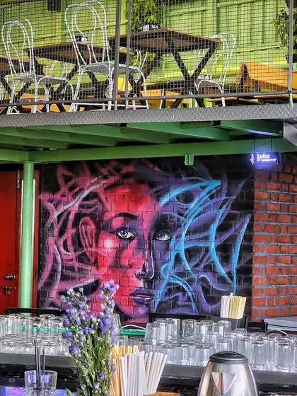 The bar area at Skydeck by Sherlocks, with our abstract spray-painted portrait adding a splash of color and urban art style to the brick wall.