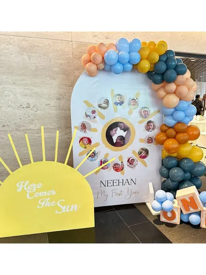 A personalized 'My First Year' photo board in the shape of the sun, a beautiful and sentimental piece for a first birthday.