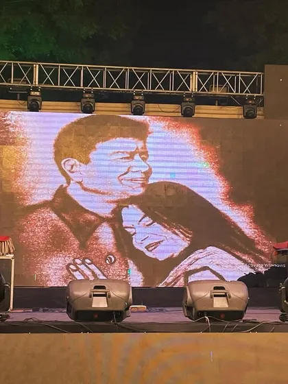 The final frame of a 25th-anniversary sand art story, projected on the big screen. This image of the couple is a touching finale to their live-drawn love story.