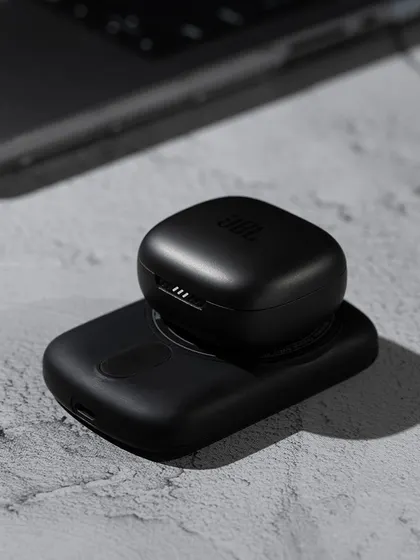 This image shows the Urbn power bank's versatility by featuring it with a set of wireless earbuds. This type of shot can be used to suggest product pairings or bundles.