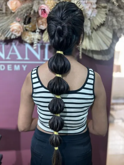 A still image of the neat and playful bubble braid, a popular request from younger clients.