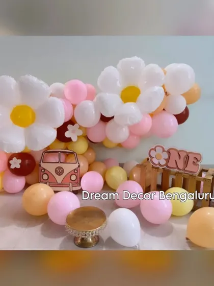 A cute and simple cake smash backdrop with a daisy theme. The pastel balloons and retro van cutout create a sweet and cheerful setting.