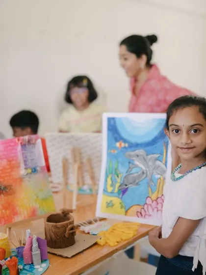 A duplicate of a proud young artist with her work.