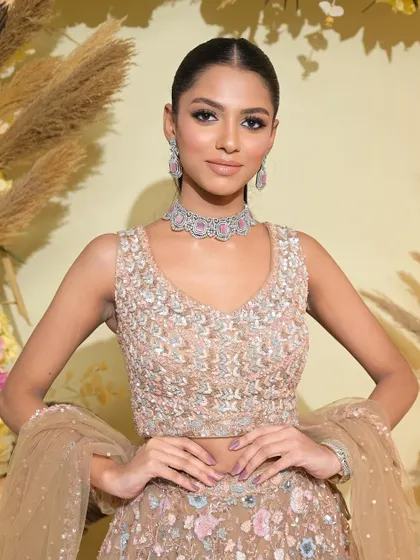 The full look is modern, chic, and powerful. The sleek ponytail and a pastel-colored lehenga create a beautiful contrast.