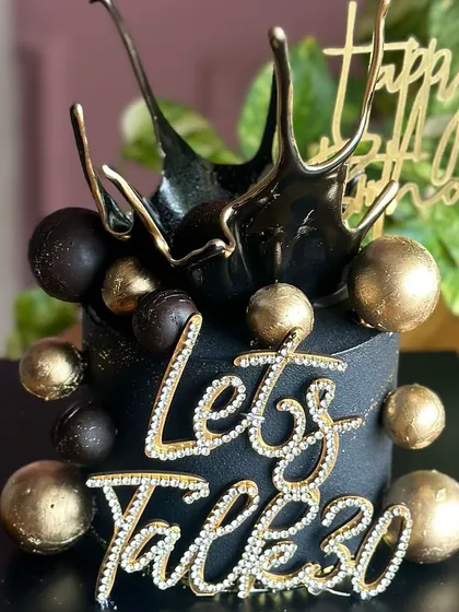 Celebrating 30 in style with this stunning black and gold birthday cake. The design features a dramatic black splash effect, gold spheres, and a sparkling "Let's Talk 30" topper.