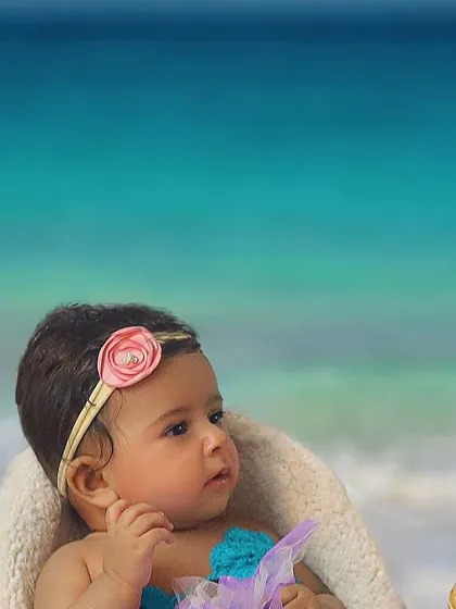 A magical mermaid theme for a beautiful baby girl. This close-up shot captures her curious and sweet expression.
