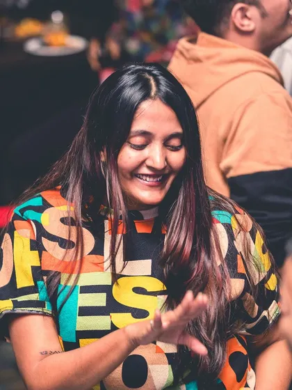 Another shot of the woman in the colorful shirt, lost in the rhythm. It's all about feeling the music.