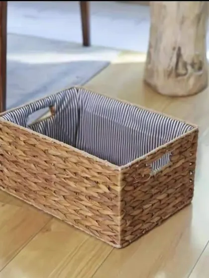 This rectangular storage basket is woven from water hyacinth and features a striped cloth liner. It's a perfect blend of natural texture and classic design, ideal for organizing shelves or keeping items tidy on the floor.