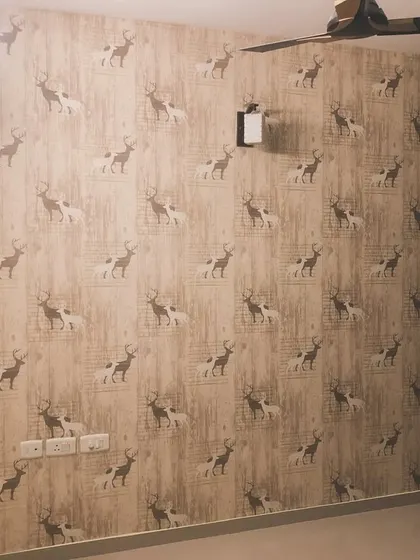 A repeating deer pattern wallpaper in a bedroom. The graphic style of the deer gives this room a modern, Scandinavian feel.