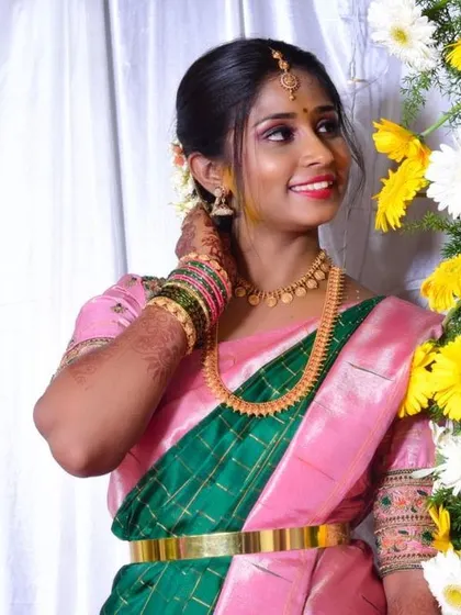 A bright and cheerful look for an engagement or pre-wedding event. The pink and green saree is paired with fresh, glowing makeup and a simple hairstyle, making her look effortlessly beautiful.