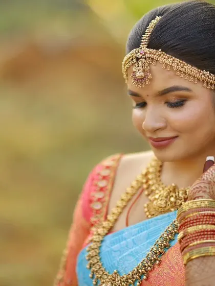 A stunning outdoor bridal portrait with a soft, golden hour glow, highlighting the bride's features and beautiful saree.