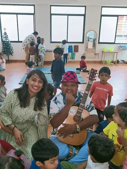 A teacher and our musical guest surrounded by happy children during our Christmas party.