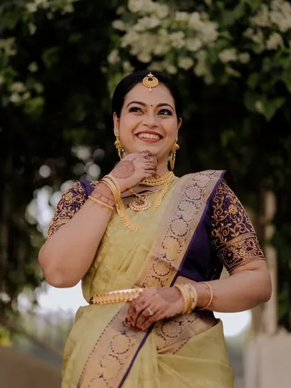 A portrait of contemporary elegance meeting timeless tradition. Her joyful smile is the centerpiece, enhanced by a subtle, radiant makeup look that complements her beautiful silk saree.