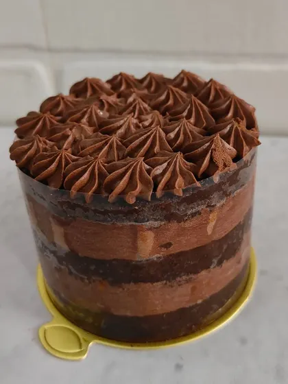 A simple yet decadent chocolate truffle mini cake. The layers of moist chocolate cake and rich truffle frosting are topped with beautiful piped details.