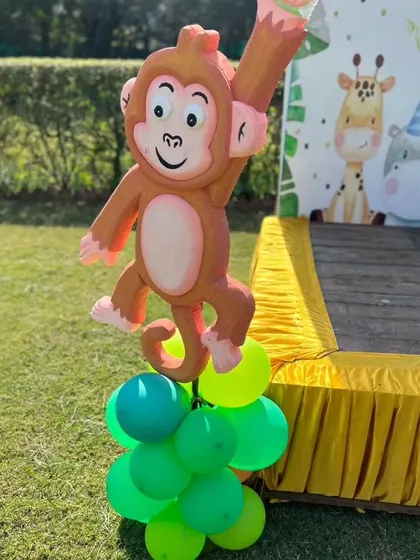A cheerful monkey cutout on a balloon base, one of the many fun props at the jungle party.