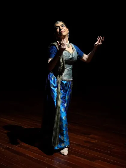 A dancer looks upward in a gesture of devotion during the "Immersed" performance.