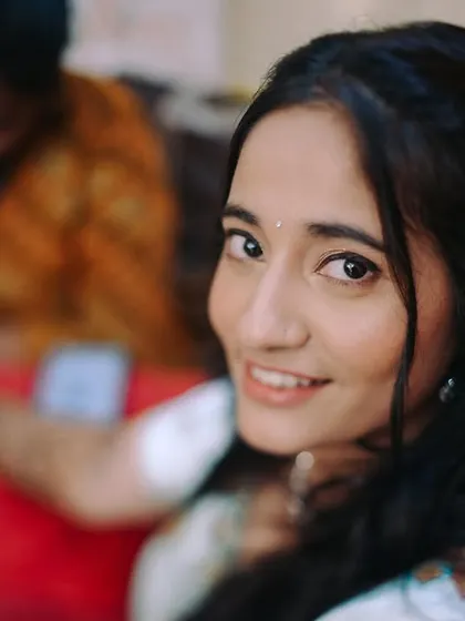 A lovely close-up of the bride looking at the camera during her mehndi application. It's a sweet, personal moment.