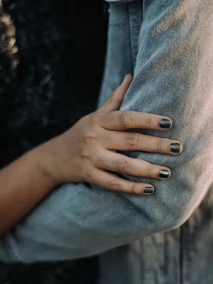 A close-up detail shot of a woman's hands as she embraces her partner. Focusing on these small gestures of affection adds an intimate and personal layer to the photoshoot.